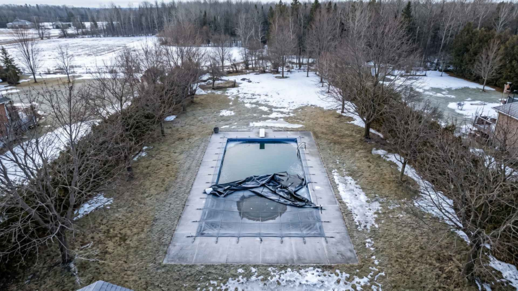 Snowy backyard pool in early spring